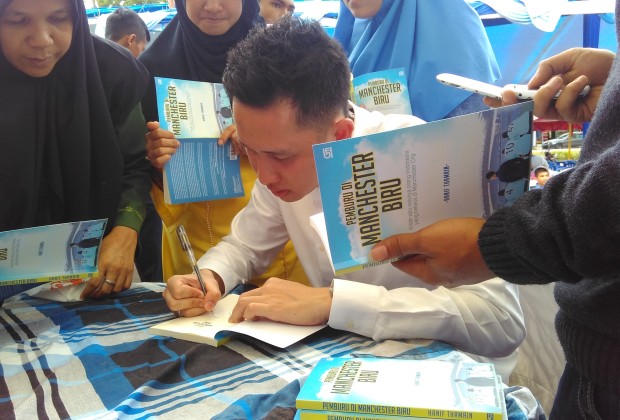 Hanif Thamrin selfie saat menandatangani buku peserta soft launching Pemburu di Manchester Biru